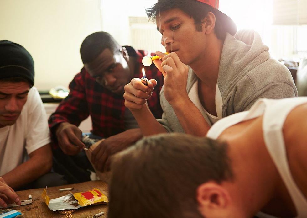 group of male friends using drugs at a party
