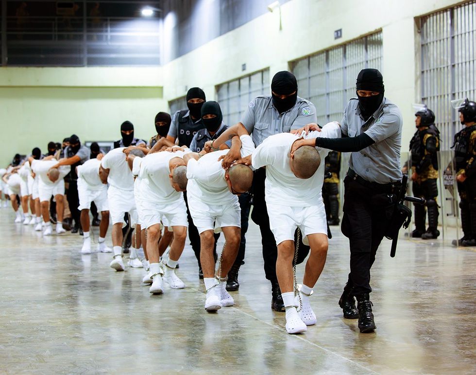 Guards escort inmates CECOT maximum security prison