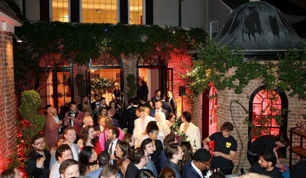 guests stand at a bar inside the grindr whcd party