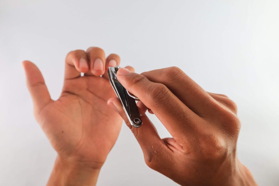 Hands using nail clippers