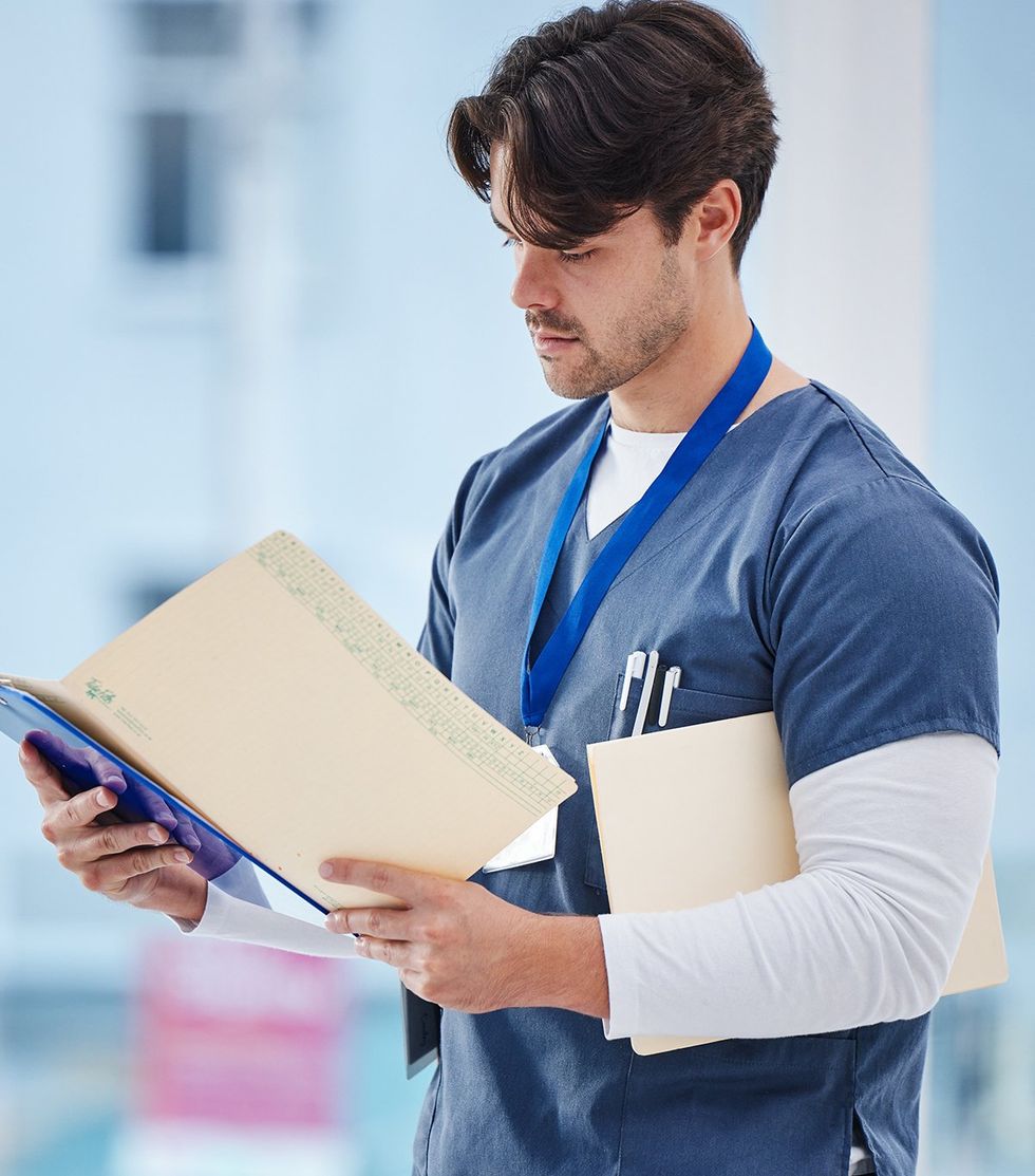 handsome young doctor reading medical files