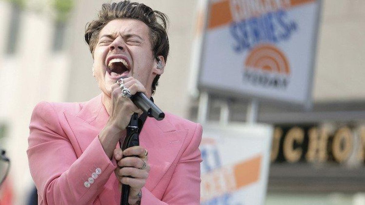 Harry Styles sings in a pink suit.