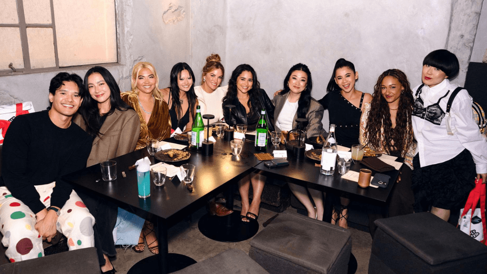 Hayley Kiyoko poses with guests around a dinner table at a Gold House and OpenTable event celebrating Girls Like Girls in Los Angeles