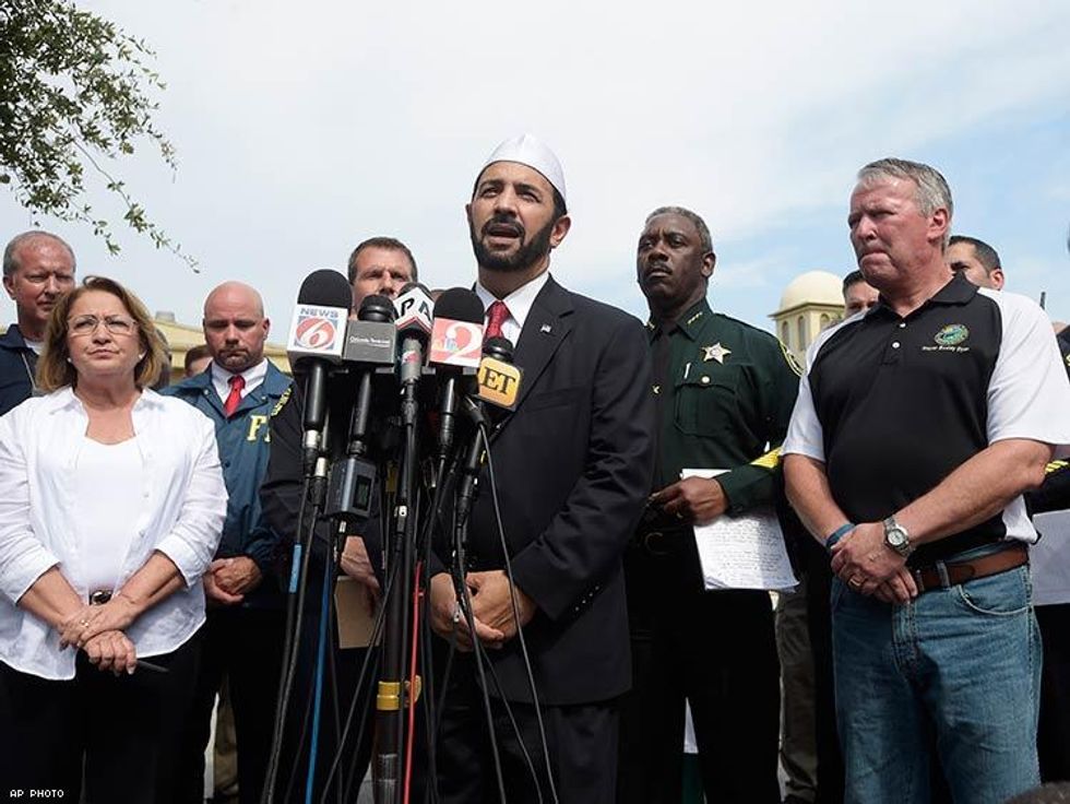 Imam Muhammad Musri, center, president of the Islamic Society of Central Florida, addresses reporters while flanked by members of law enforcement.