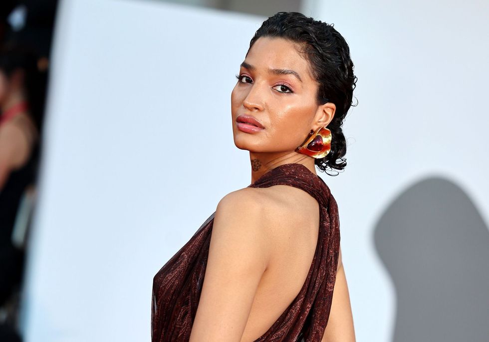 Indya moore looks over shoulder at the "father mother sister brother" red carpet
