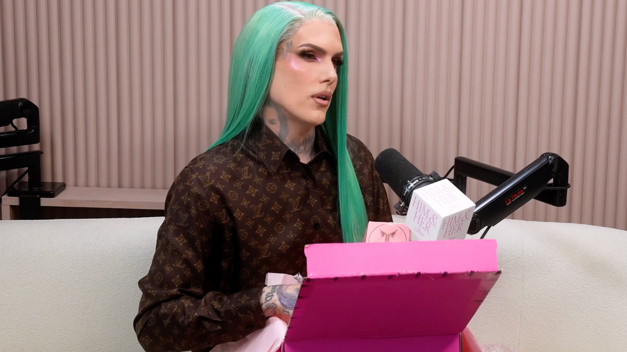 Jeffree Star sitting on a couch with an open pink box