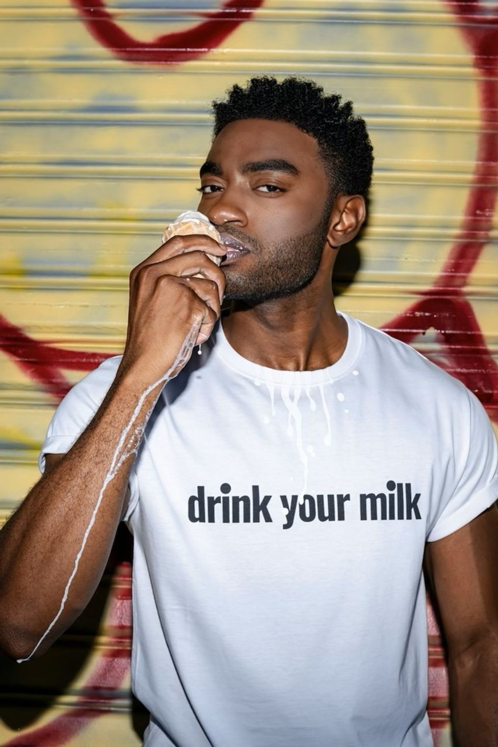 Jelani Alladin wears the Loewe "Drink Your Milk" t-shirt to support The Shameless Fund.