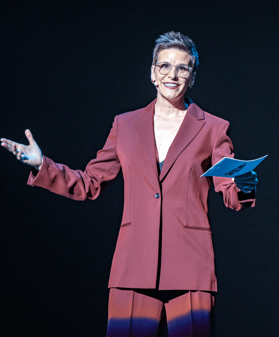 Jenn Colella speaks onstage while hosting Broadway Backwards.