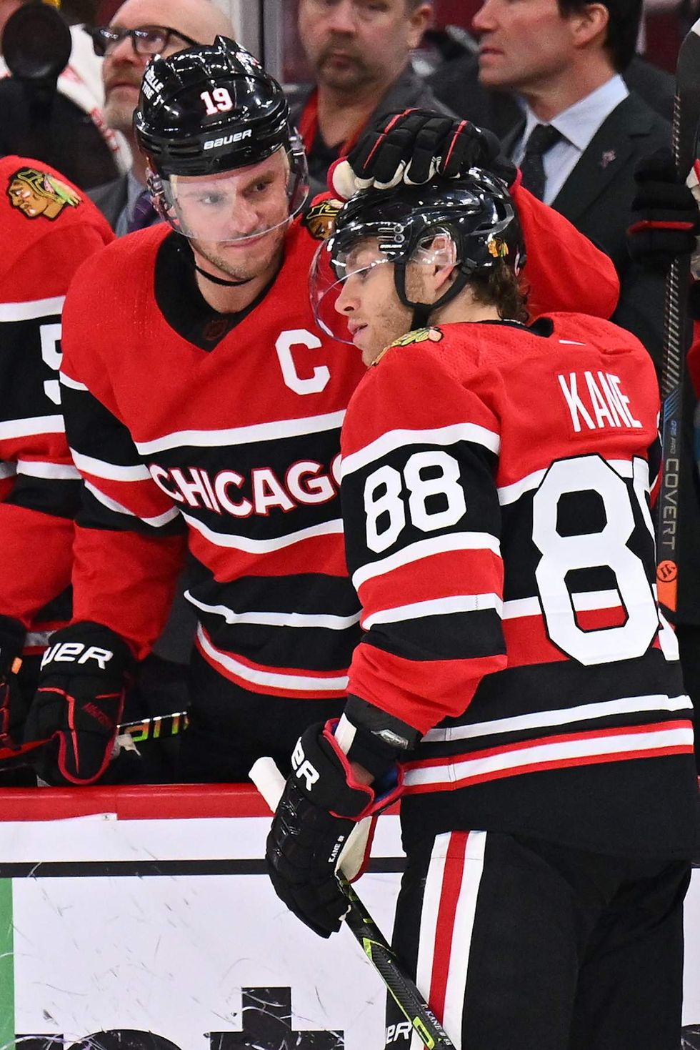 Jonathan Toews #19 of the Chicago Blackhawks and Patrick Kane #88 congratulate each other after being honored for playing their 1000th game together as teammates