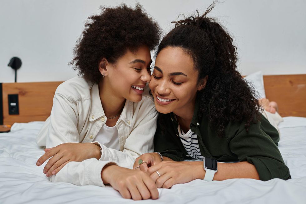 Lesbian couple lying in bed talking