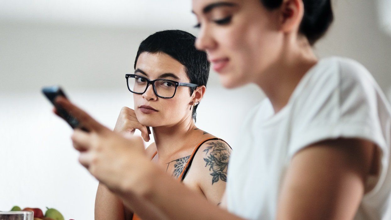 lesbian looks suspiciously at girlfriend on the phone