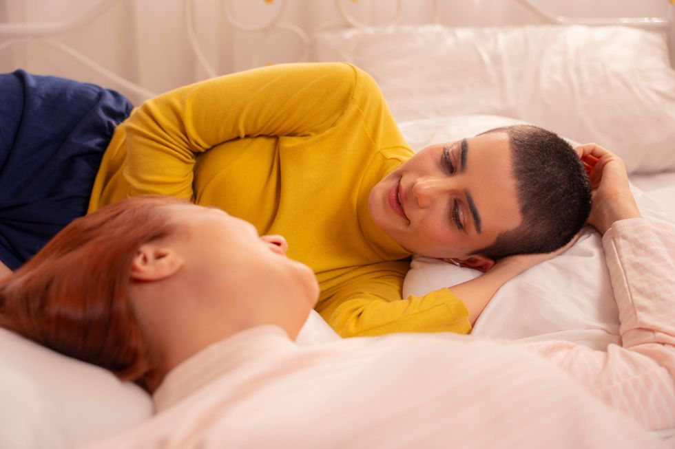 Lesbians lying in bed together.