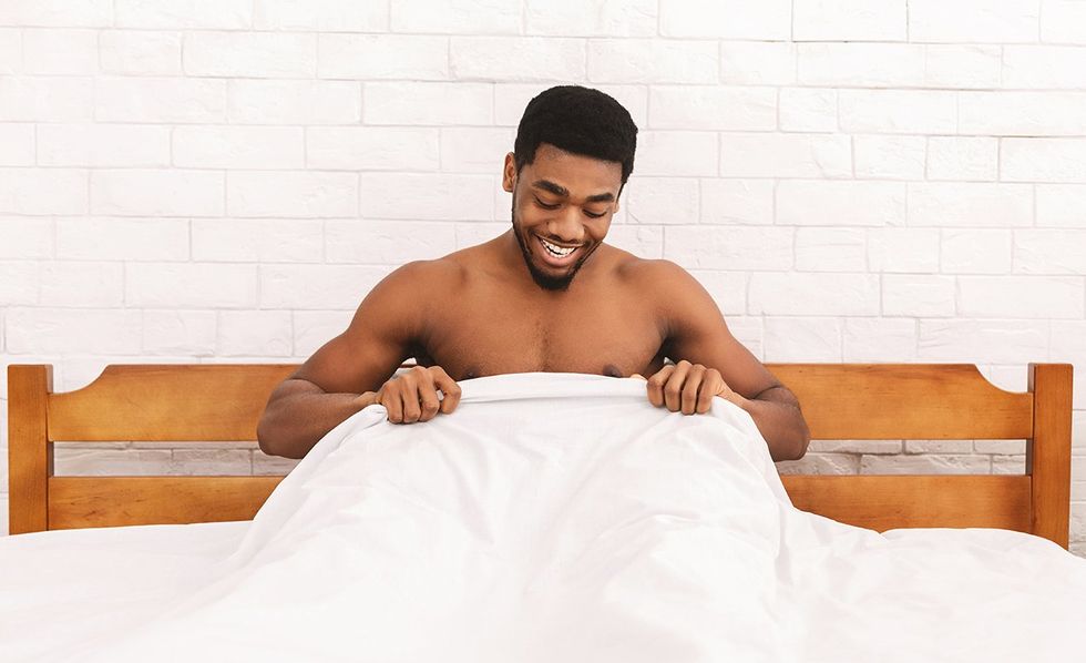 man admiring himself in bed