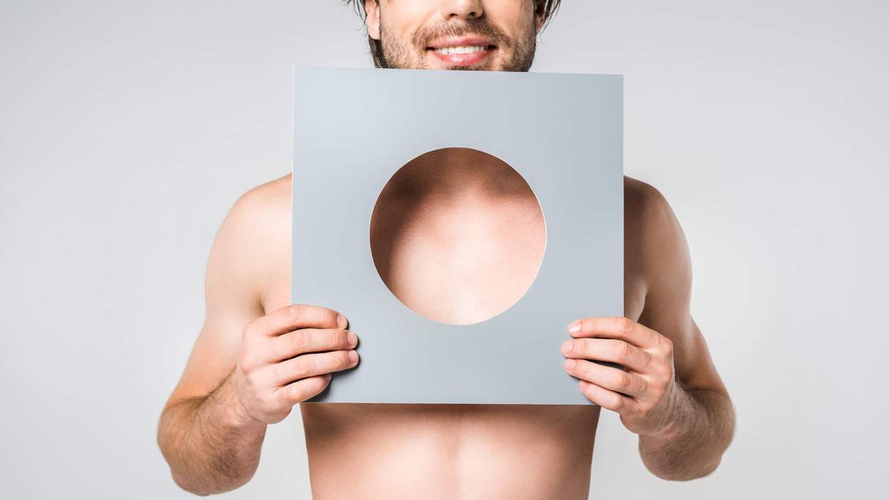 man holding a paper with a circle cut out of the middle