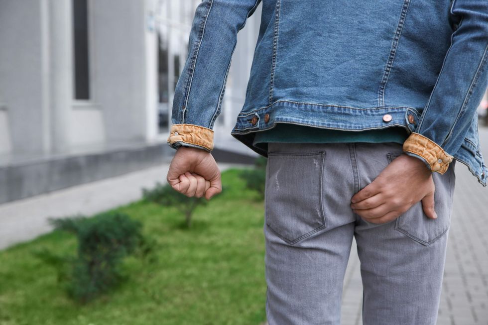 Man holding his butt and he's walking