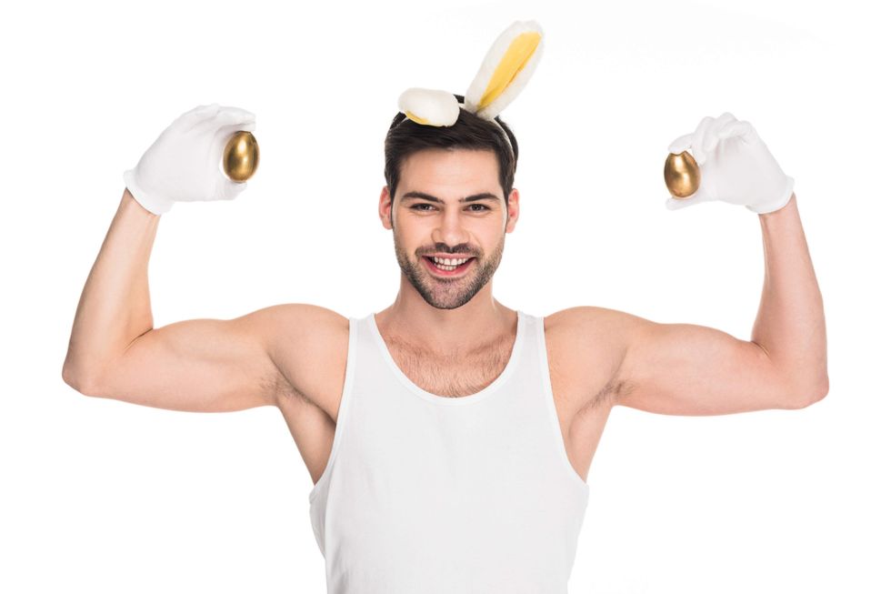 Man in a bunny costume holding golden eggs