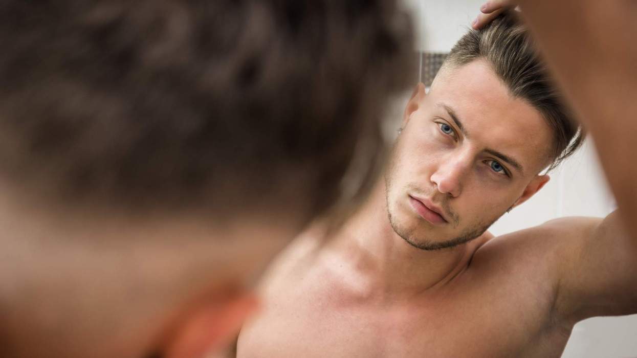 Man looking in the mirror at his hair