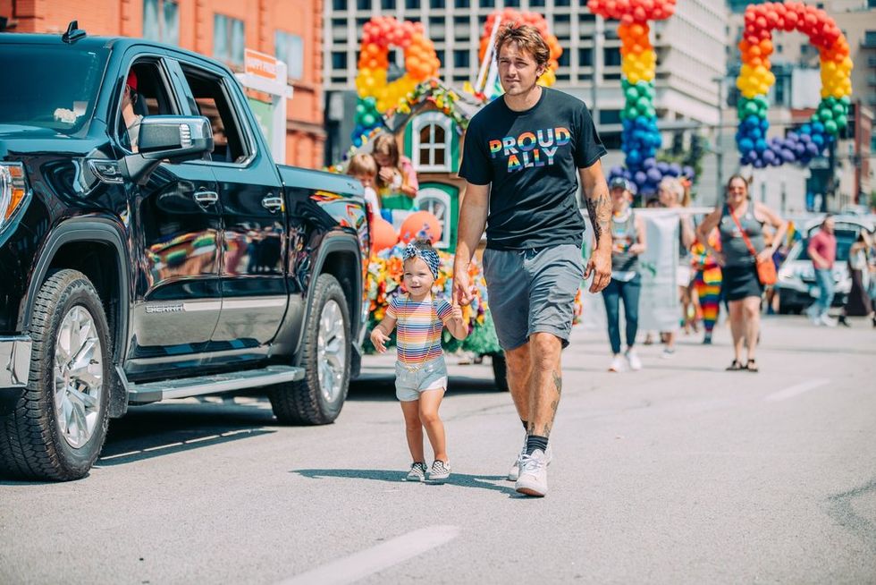 Man wearing "proud ally" shirt with young daughter at Omaha Pride Parade (2021)\u200b