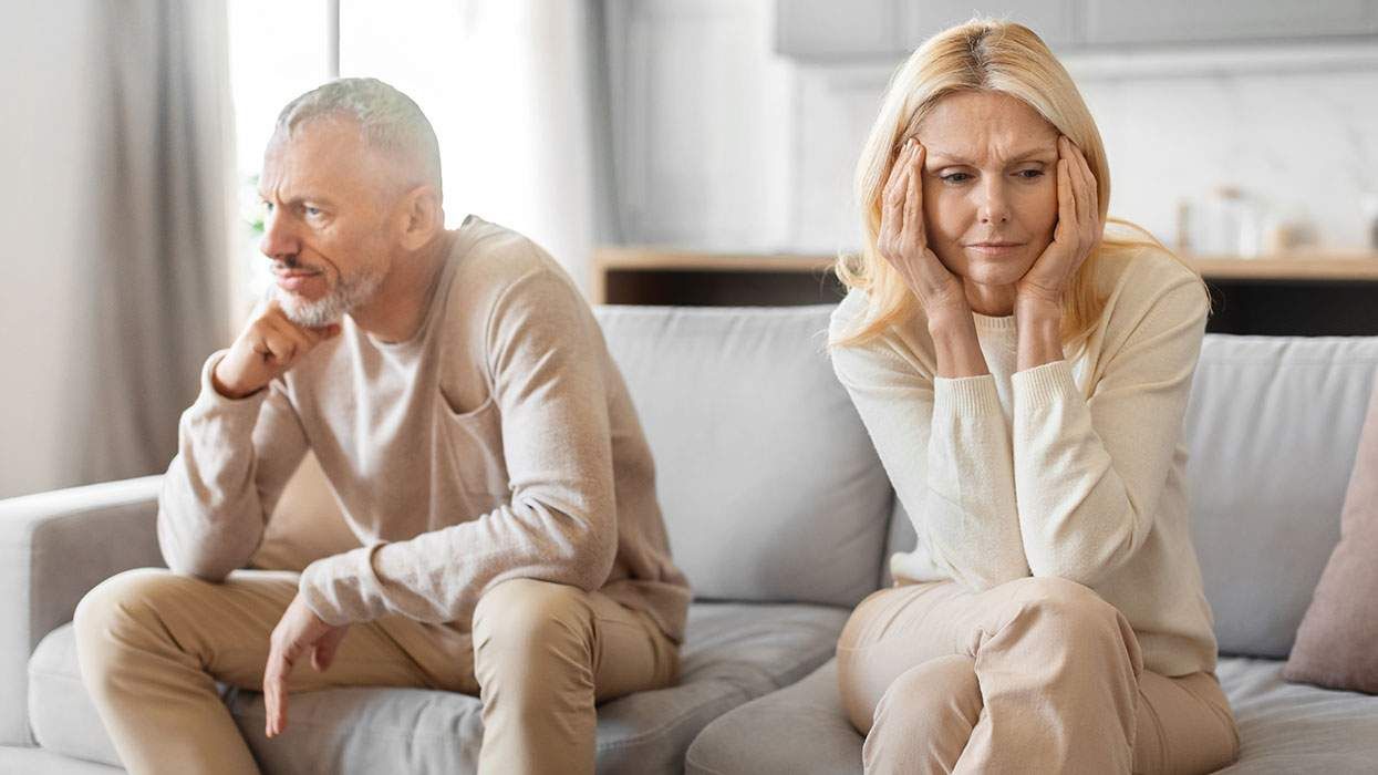 Middle-aged man and woman sit apart