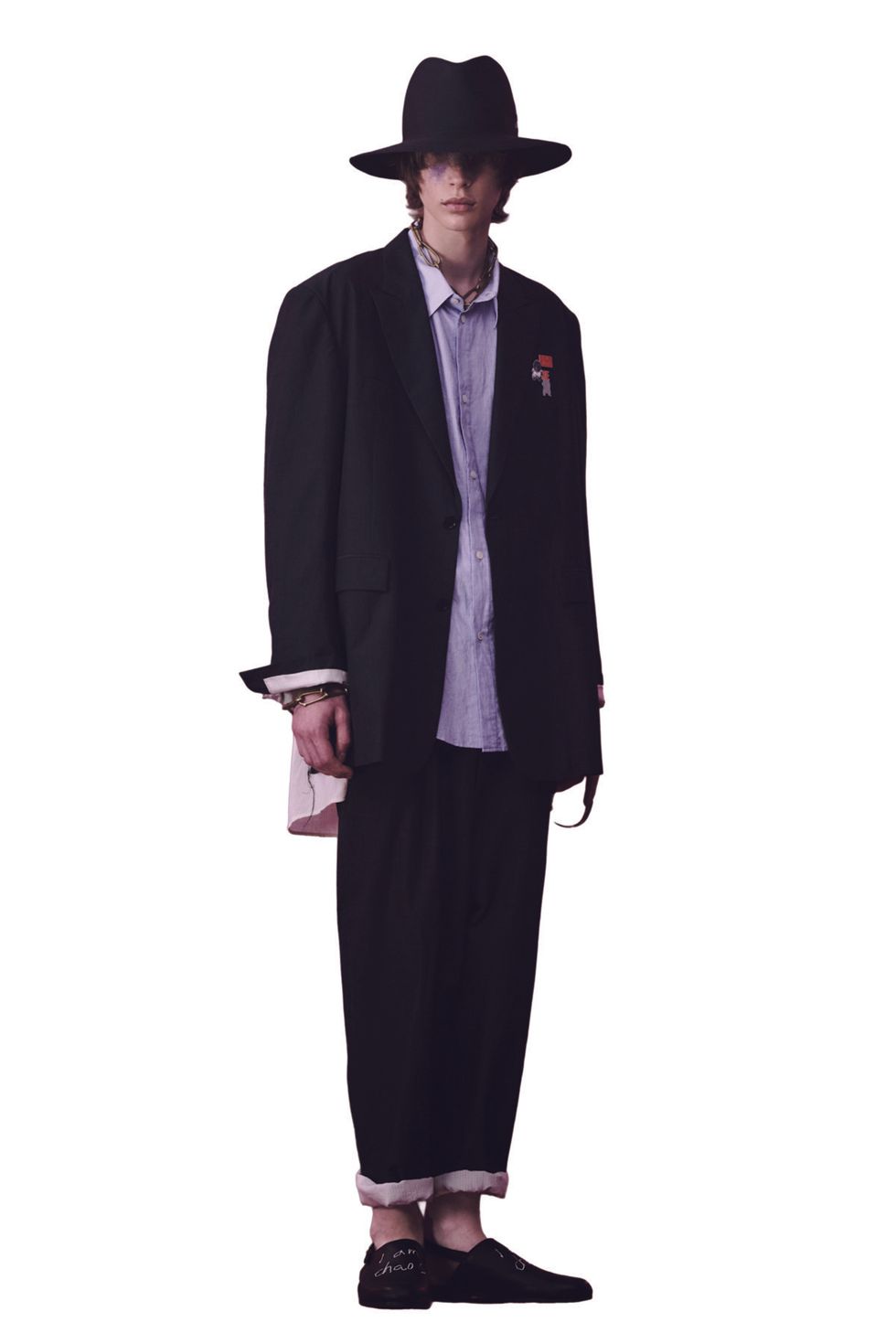 model wearing wide-brimmed hat with baggy oversized suit by UNDERCOVER