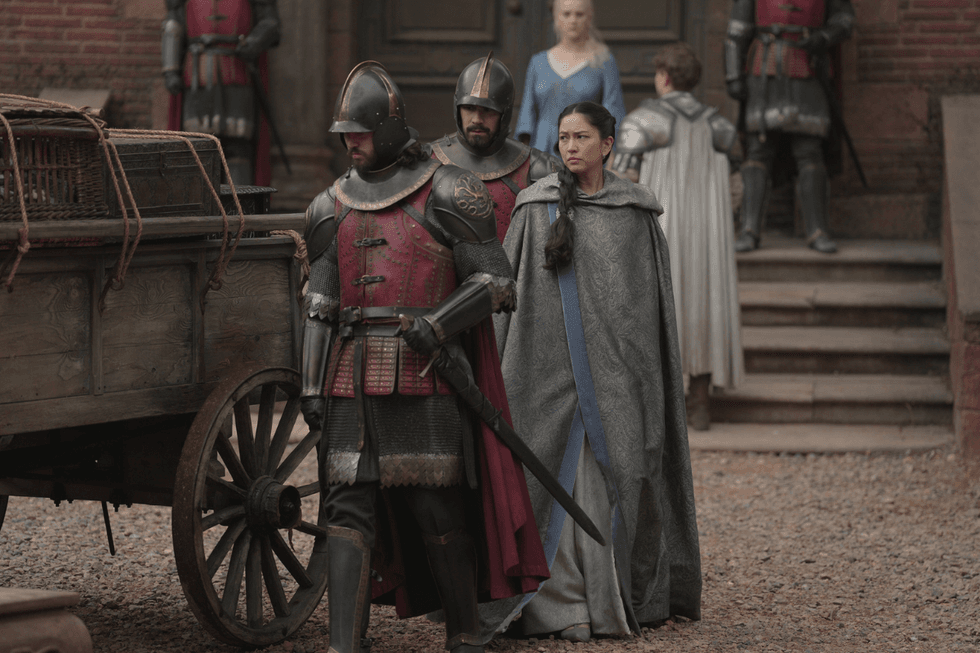 Mysaria walks beside an armored guard after being dismissed by Rhaenyra in the House of the Dragon season 3 finale.