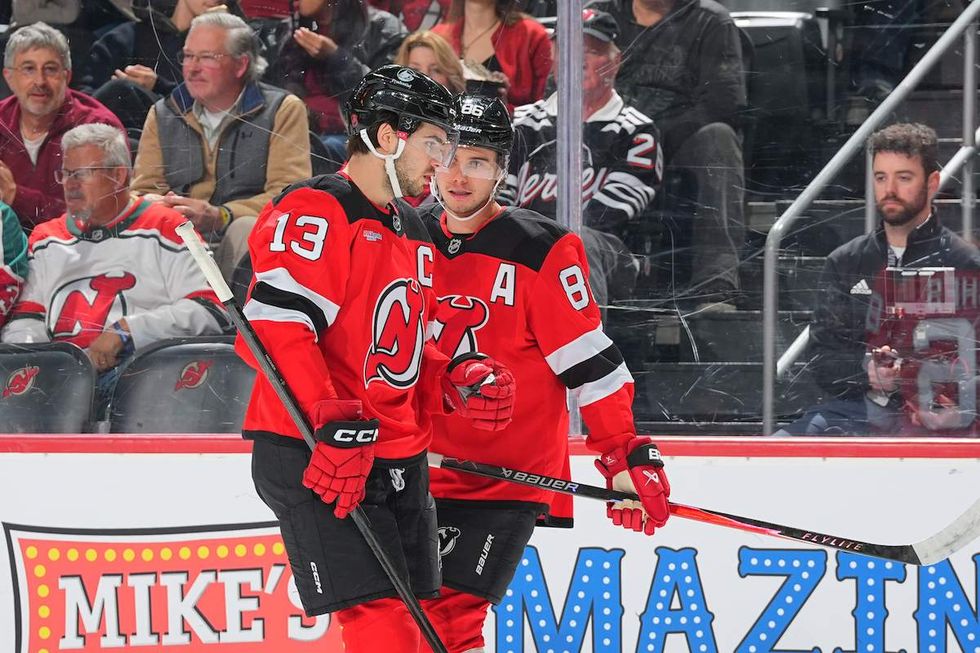 Nico Hischier #13 of the New Jersey Devils and Jack Hughes #86 of the New Jersey Devils skate during the first period of the game against the Minnesota Wild