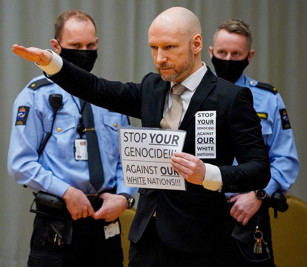 Norwegian mass murderer Anders Behring Breivik who now calls himself Fjotolf Hansen raises his arm to make a Nazi salute as he arrives on the first day of the trial where he is requesting release on parole_RMwebinterior