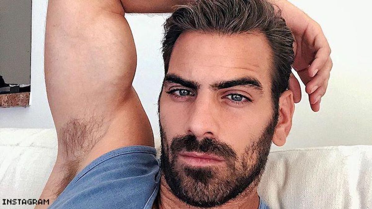 Nyle Dimarco reclining on his couch.