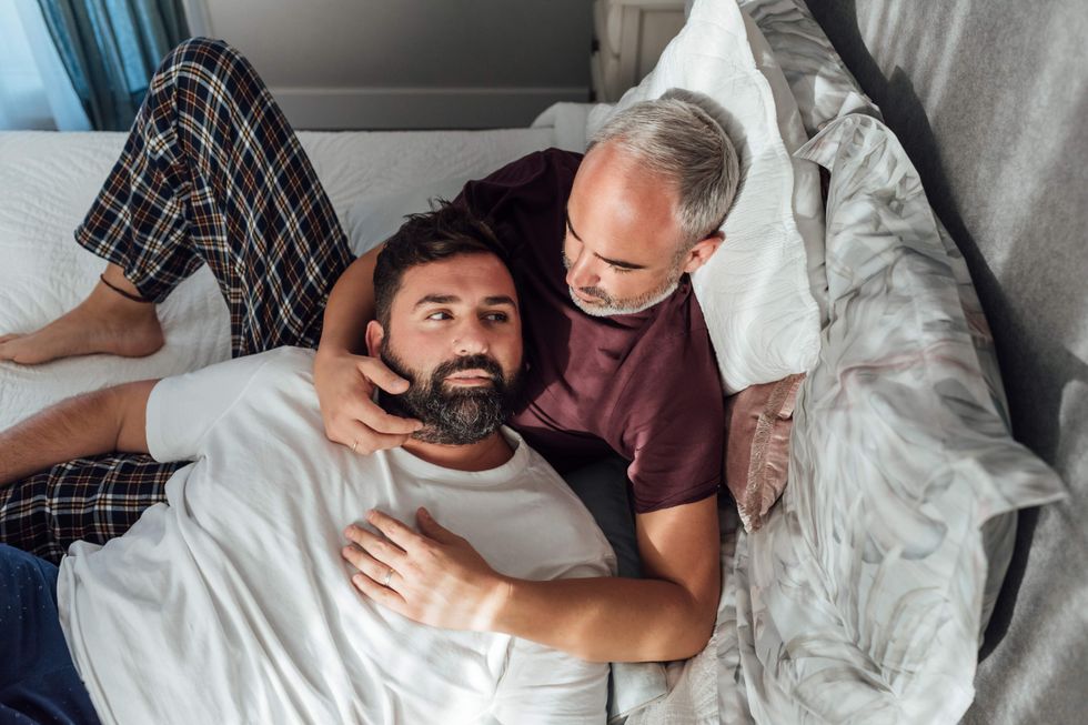 Older gay couple snuggling in bed