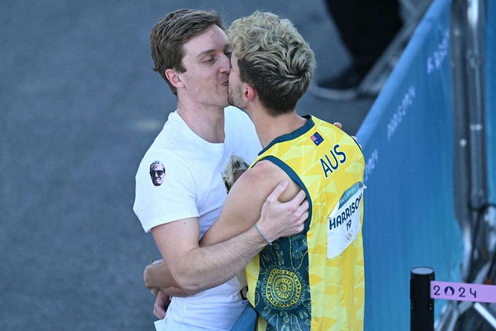 Olympic rock climber Campbell Harrison kisses his boyfriend.