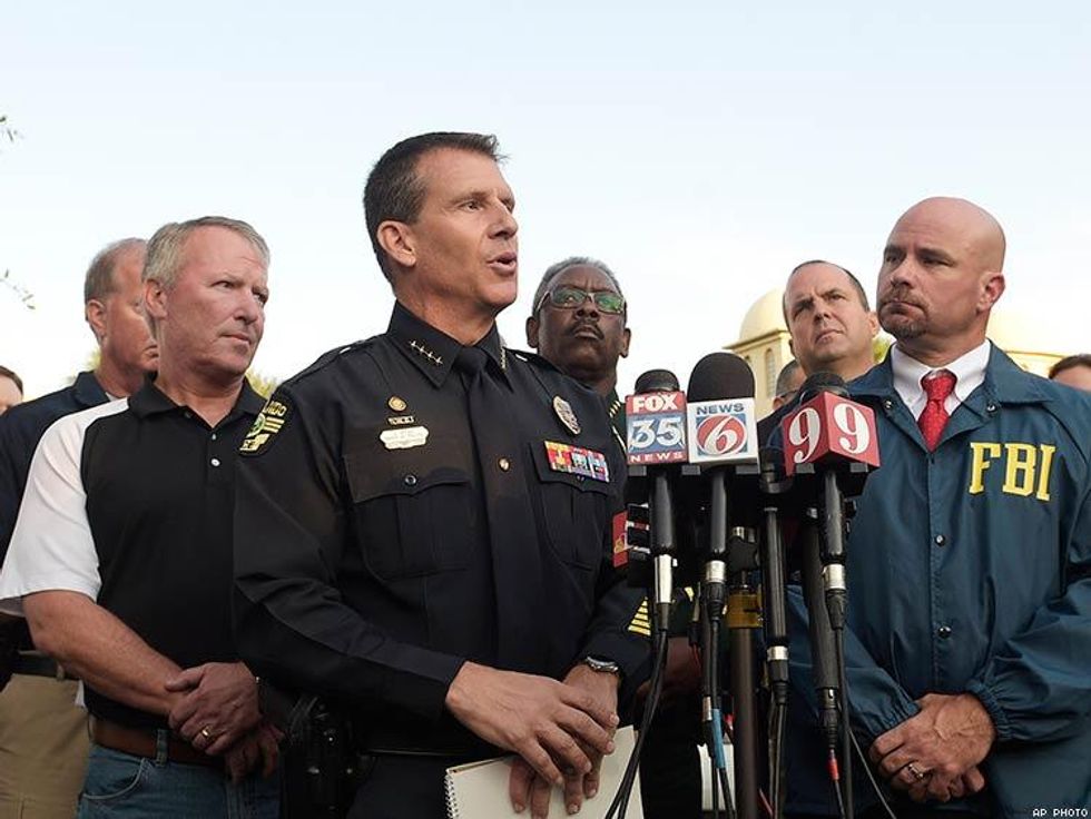 Orlando Police Chief John Mina, center, addresses reporters during a news conference.