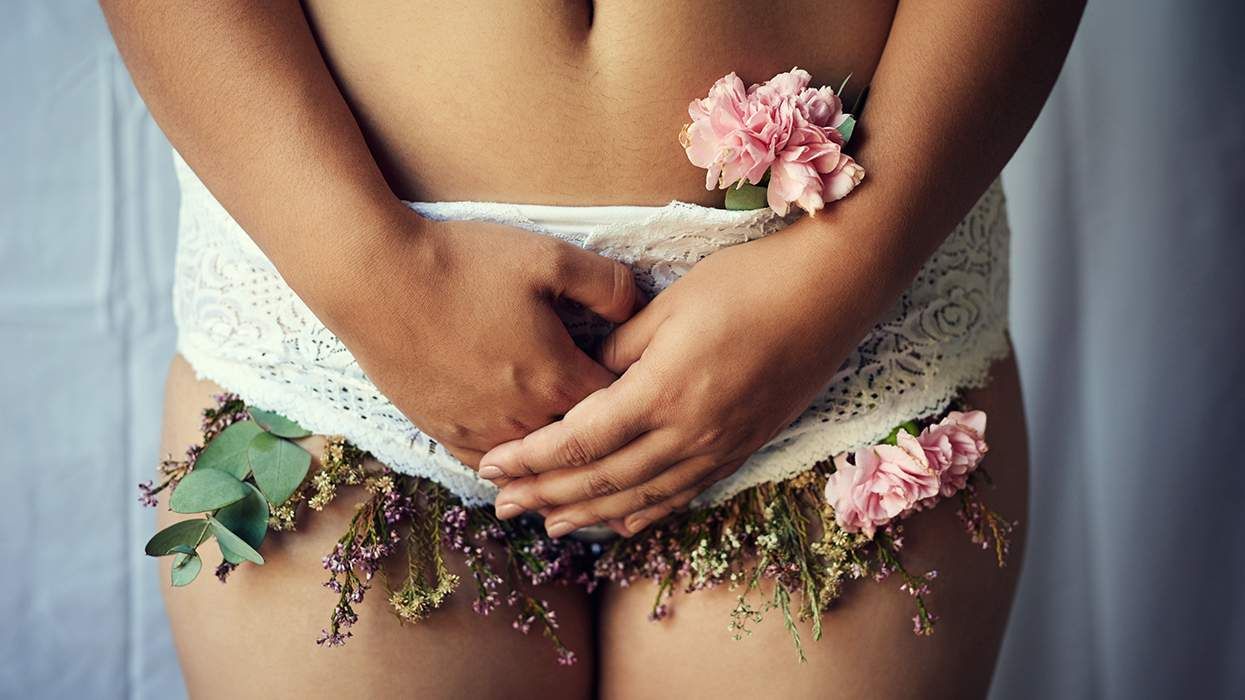 person from waist to thighs wearing white lace underwear with dried and fresh flowers around the edges