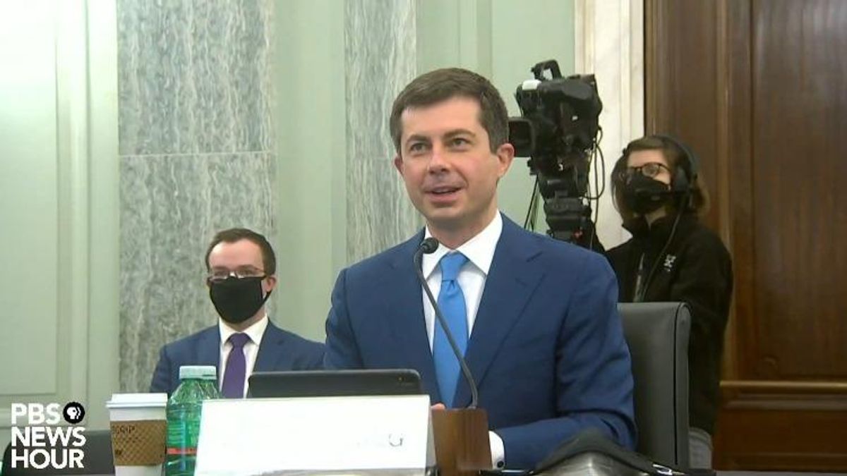 Pete Buttigieg introduced and thanked his husband, Chasten Buttigieg (in background), at his senate confirmation hearing considering his historic nomination for secretary of transportation.