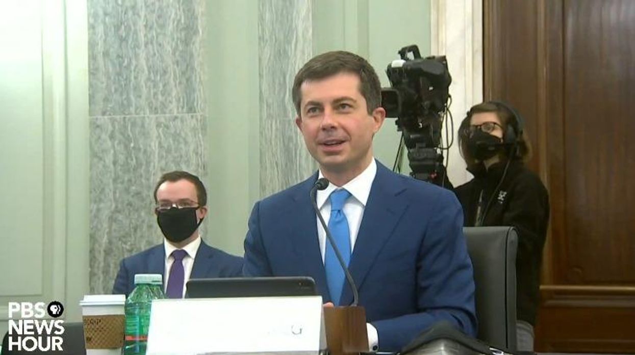Pete Buttigieg introduced and thanked his husband, Chasten Buttigieg (in background), at his senate confirmation hearing considering his historic nomination for secretary of transportation.