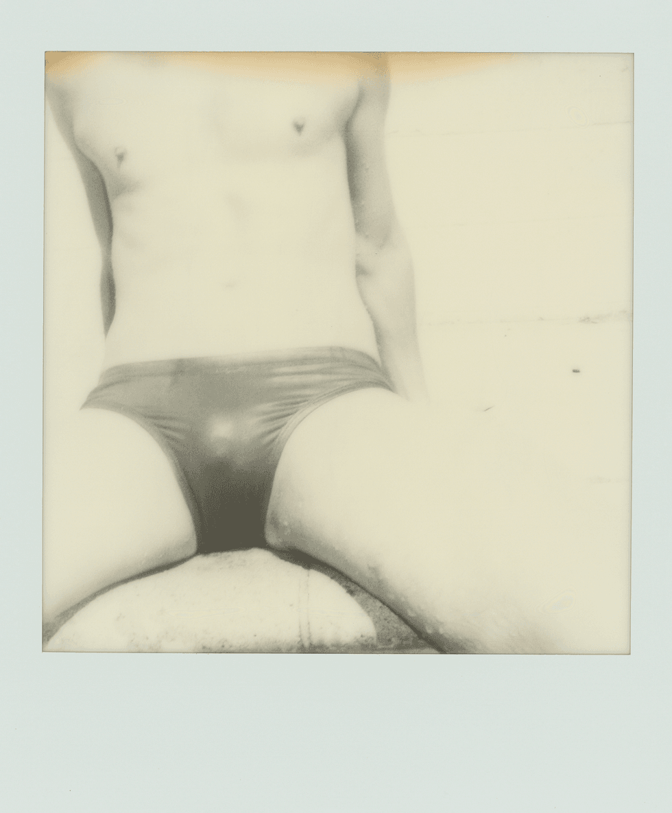 Polaroid close-up of a person\u2019s torso wearing briefs.