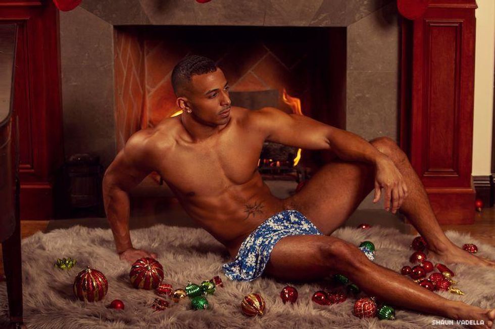 Porn performer Zario sitting in front of the fire in his underwear.