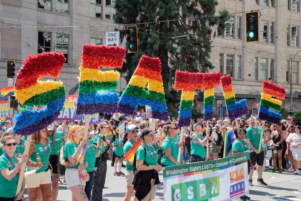 Pride parade with SEATTLE spelled out in rainbow colors\u200b