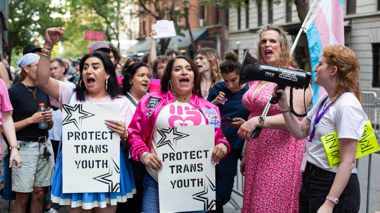 Protestors holding signs outside of Mount Sinai reading "protect trans youth"