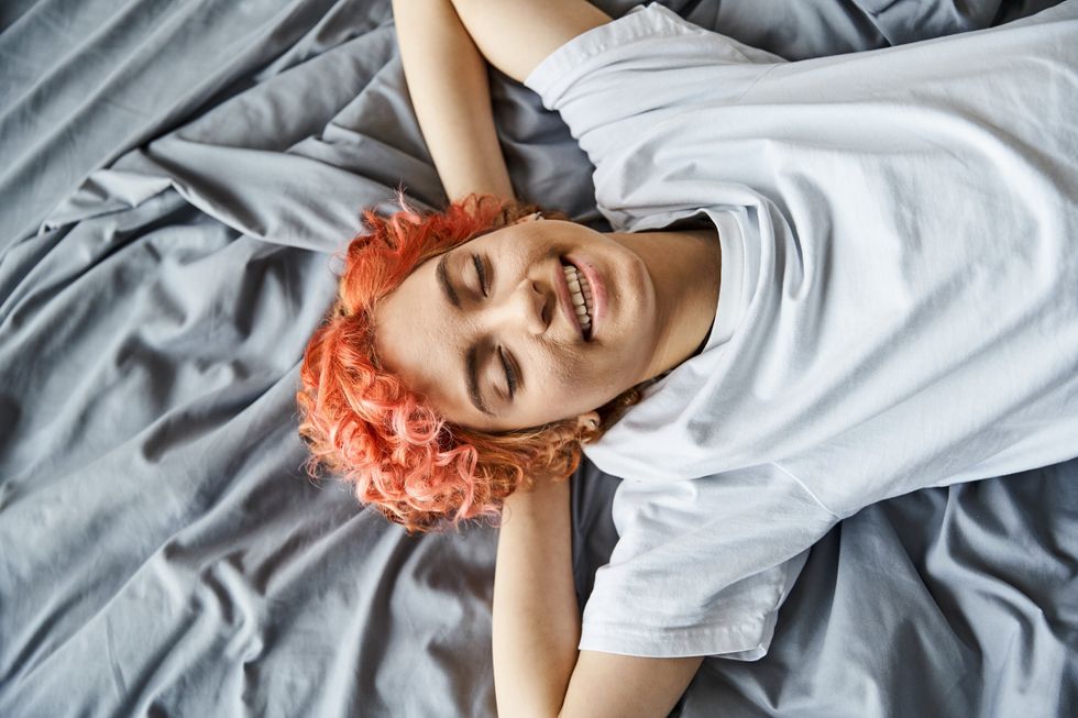Queer woman lying in bed