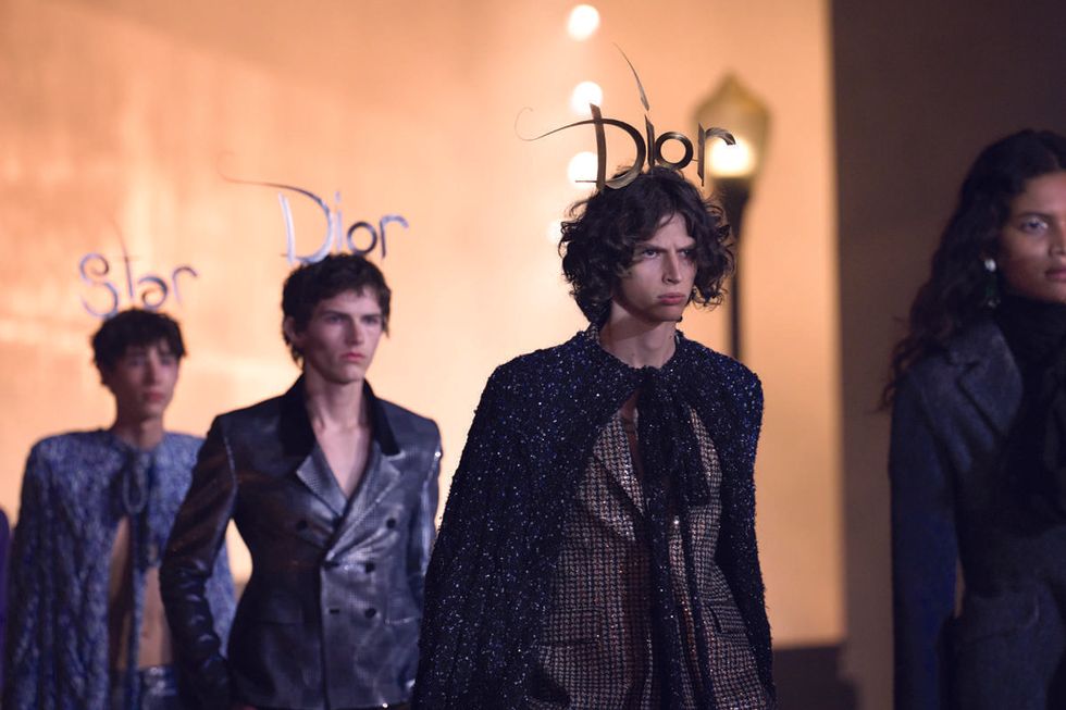 Runway models wear headpieces created by Phillip Treacy for Dior Cruise men\u2019s looks
