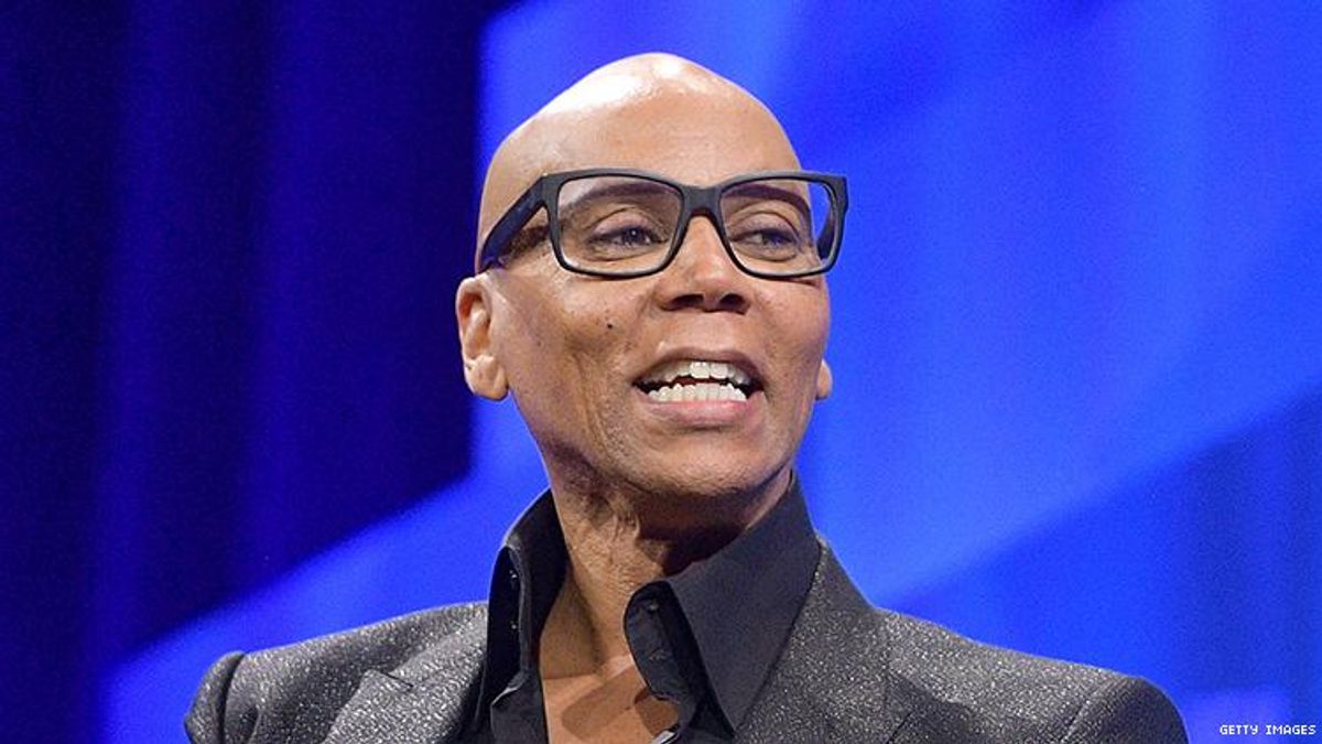 RuPaul, out of drag, laughing while giving a speech.