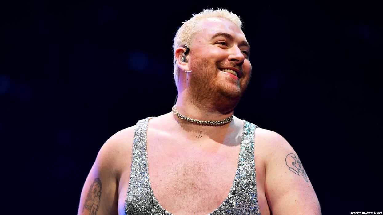 sam smith wearing a silver sparkly tank top and smiling