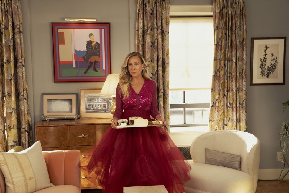 Sarah Jessica Parker as Carrie Bradshaw standing and holding a tray.