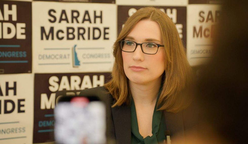 sarah mcbride sitting in front of campaign signs