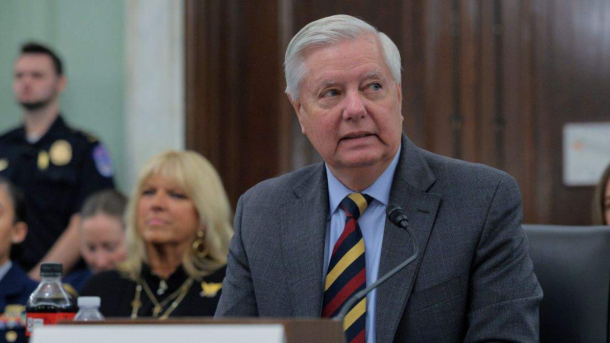 Senator Lindsey Graham speaking at a microphone in a formal setting.