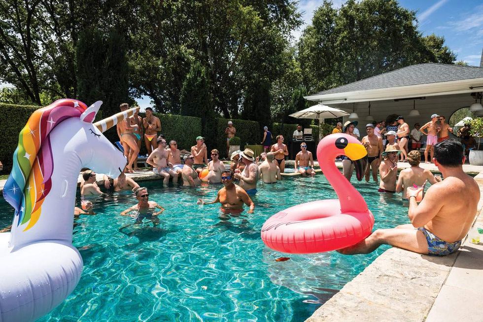Several men in swimsuits lounge in and around a swimming pool at Sonoma Valley's Gay Wine Weekend