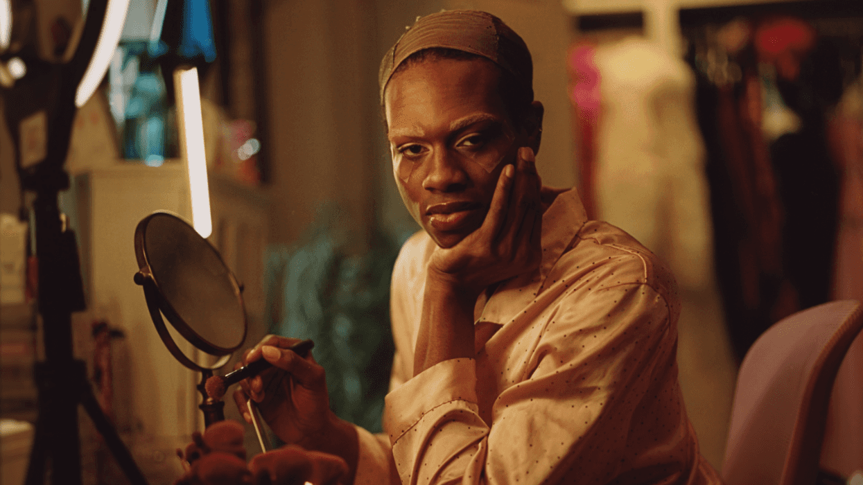 Shamari sits at a vanity applying makeup in a warmly lit room in South Carolina.