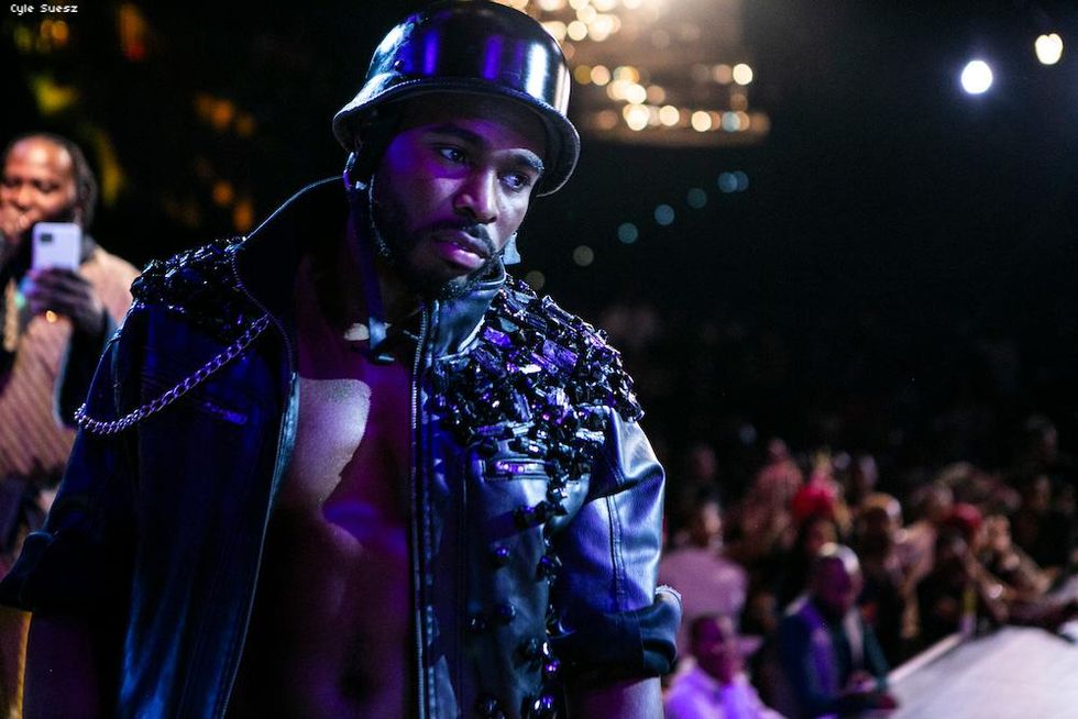 Shirtless man in a bejeweled leather jacket.