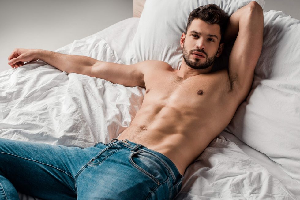 Shirtless man lying in bed