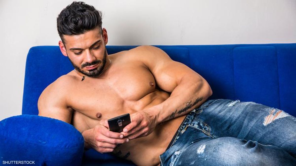 Shirtless man texting on his phone. 